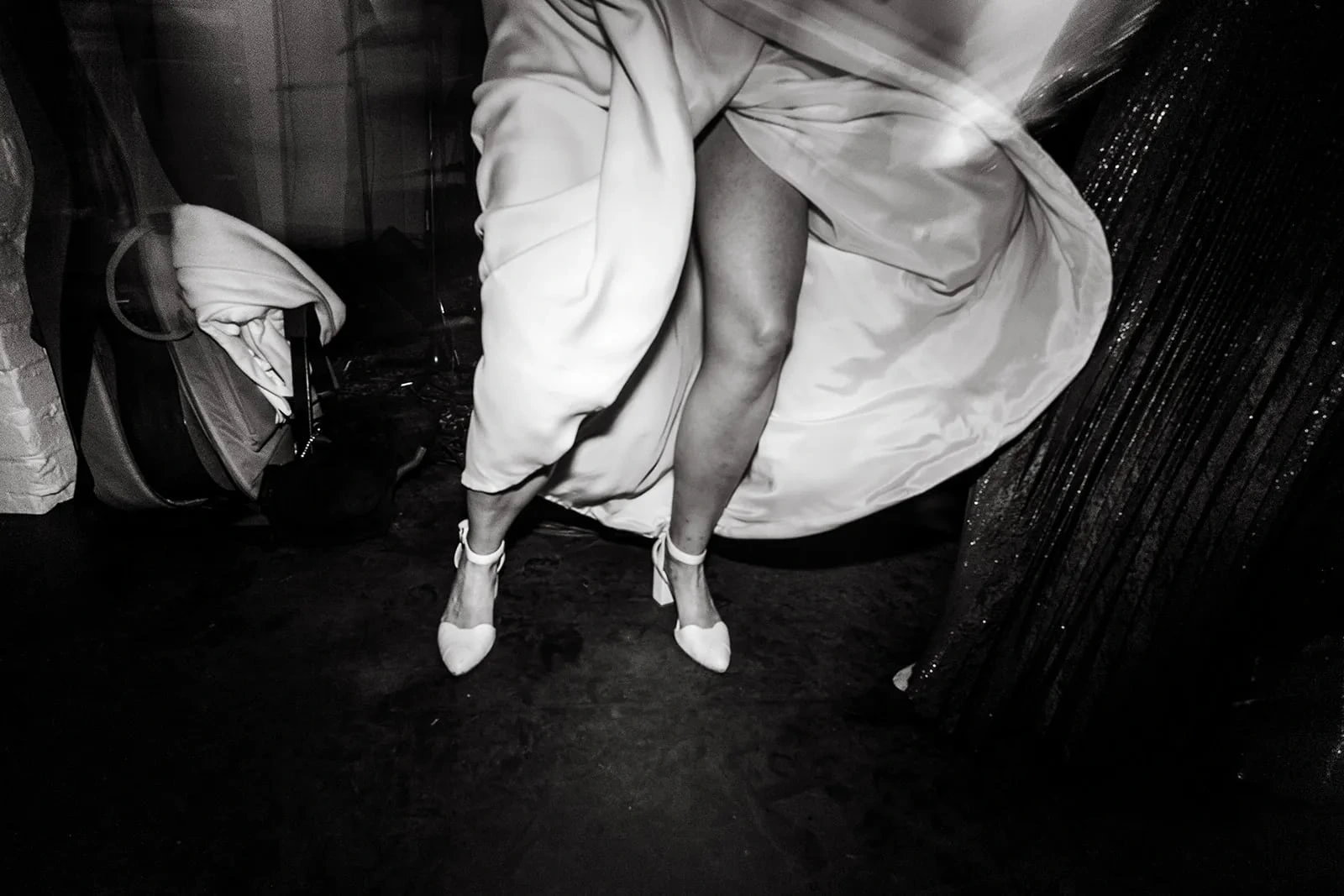 Black-and-white close-up of a person bending down while dancing